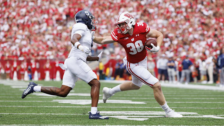 Sep 16, 2023; Madison, Wisconsin, USA;  Wisconsin Badgers tight end Tucker Ashcraft (38) stiff arms Georgia Southern Eagles defensive back TJ Smith (5) during the third quarter at Camp Randall Stadium.