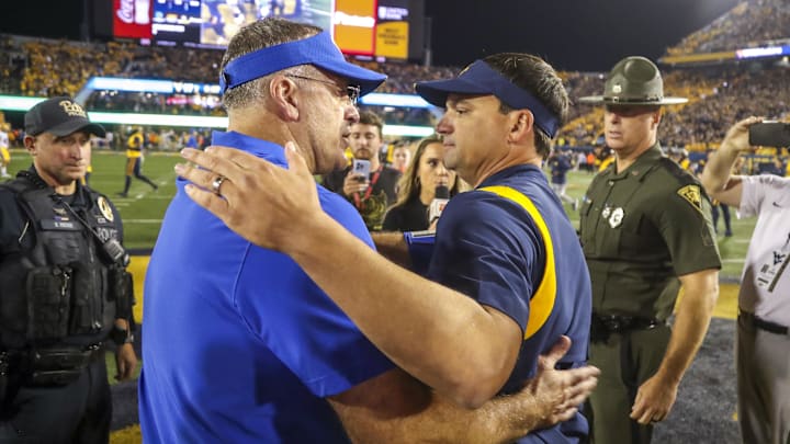 Sep 16, 2023; Morgantown, West Virginia, USA; West Virginia Mountaineers head coach Neal Brown speaks with Pittsburgh Panthers head coach Pat Narduzzi after the game at Mountaineer Field at Milan Puskar Stadium. Mandatory Credit: Ben Queen-Imagn Images