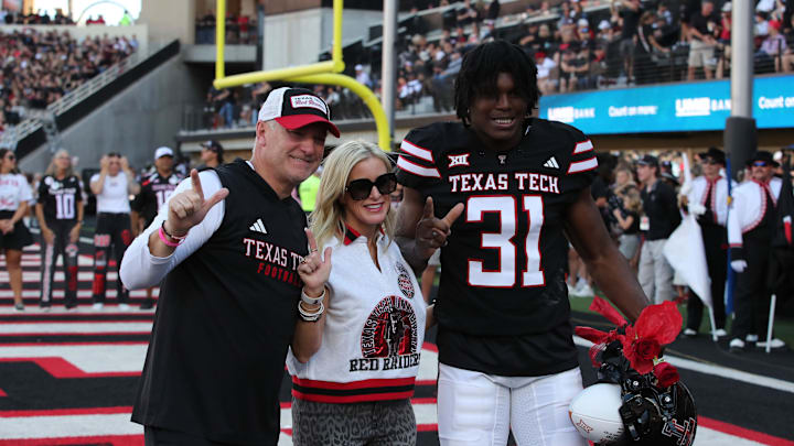 Nov 15, 2025; Lubbock, Texas, USA;  Texas Tech Red Raiders head coach Joey McGuire and wife Debbie celebrate senior day with Texas Tech Red Raiders defensive end David Bailey (31) before the game against the Central Florida Knights at Jones AT&T Stadium. Mandatory Credit: Michael C. Johnson-Imagn Images