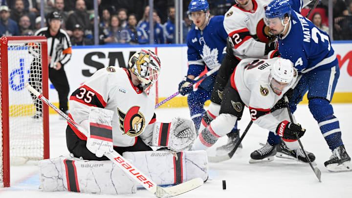 Mar 15, 2025; Toronto, Ontario, CAN;  Ottawa Senators goalie Linus Ullmark (35) makes a save as defensemen Artem Zub (2) and Thomas Chabot (72) hold back Toronto Maple Leafs forward Auston Matthews (34) in the third period at Scotiabank Arena. Mandatory Credit: Dan Hamilton-Imagn Images