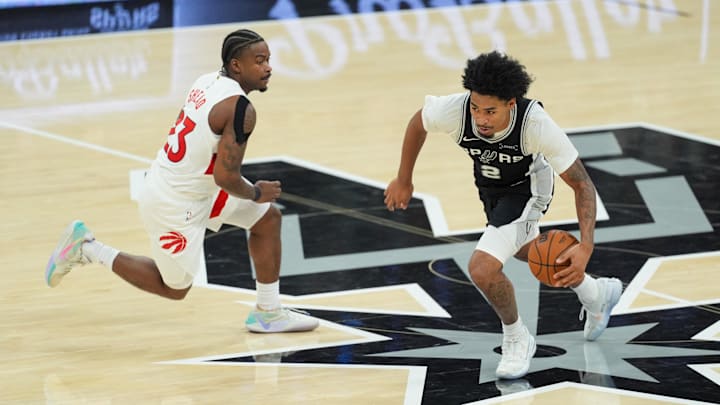Oct 27, 2025; San Antonio, Texas, USA;  San Antonio Spurs guard Dylan Harper (2) dribbles past Toronto Raptors guard Jamal Shead (23) in the second half at Frost Bank Center.