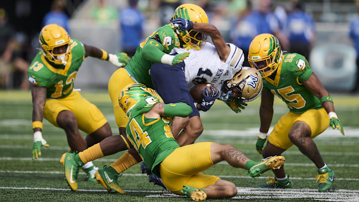 Aug 30, 2025; Eugene, Oregon, USA; Oregon Ducks linebacker Kamar Mothudi (33) and defensive back Zach Grisham (24) tackle Montana State Bobcats wide receiver Jabez Woods (10) during the second half at Autzen Stadium. Mandatory Credit: Troy Wayrynen-Imagn Images