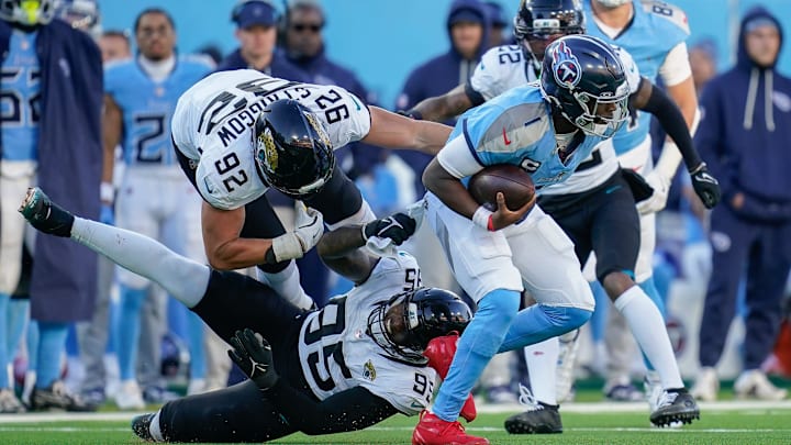Jacksonville Jaguars defensive end Danny Striggow (92) and defensive end BJ Green II (95) try to grab Tennessee Titans quarterback Cam Ward (1) on a keeper during the fourth quarter at Nissan Stadium in Nashville, Tenn., Sunday, Nov. 30, 2025. Jacksonville Jaguars defensive end Danny Striggow (92) and defensive end BJ Green II (95) try to grab Tennessee Titans quarterback Cam Ward (1) on a keeper during the fourth quarter at Nissan Stadium in Nashville, Tenn., Sunday, Nov. 30, 2025.