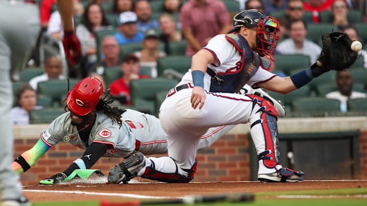 Jul 22, 2024; Atlanta, Georgia, USA; Cincinnati Reds shortstop Elly De La Cruz (44) slides safely past Atlanta Braves catcher Sean Murphy (12) in the first inning at Truist Park. Mandatory Credit: Brett Davis-Imagn Images