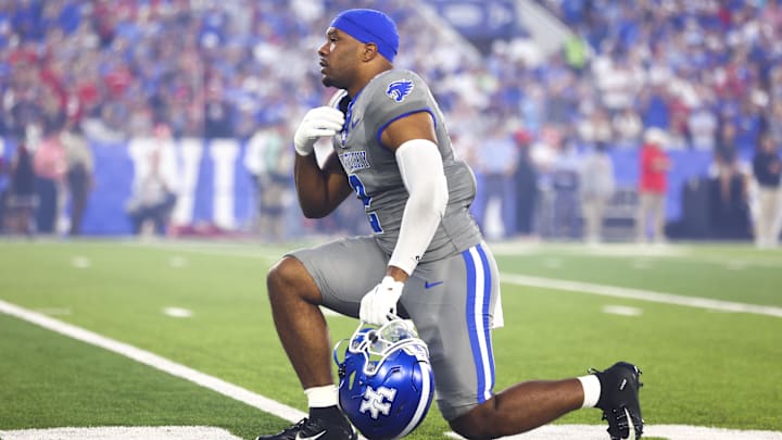 Sep 14, 2024; Lexington, Kentucky, USA; Kentucky Wildcats linebacker Jamon Dumas-Johnson (2) makes the sign of the cross while taking a knee before the game against Georgia Bulldogs at Kroger Field. Georgia won 13-12. Mandatory Credit: Carter Skaggs-Imagn Images