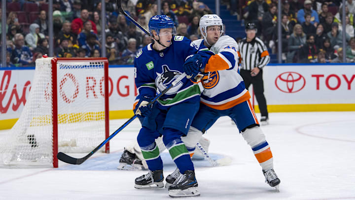 Nov 14, 2024; Vancouver, British Columbia, CAN; Vancouver Canucks forward Jonathan Lekkerimaki (23) battles with New York Islanders forward Jean-Gabriel Pageau (44) during the third period at Rogers Arena. Mandatory Credit: Bob Frid-Imagn Images
