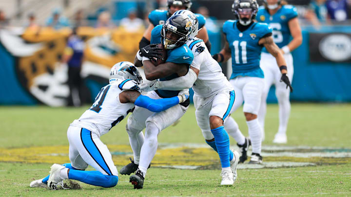 Jacksonville Jaguars running back Travis Etienne Jr. (1), center, rushes for yards against Carolina Panthers safety Nick Scott (21), left, and safety Tre'von Moehrig (7) during the fourth quarter of an NFL football matchup at EverBank Stadium, Sunday, Sept. 7, 2025 in Jacksonville, Fla. The Jaguars defeated the Panthers 26-10. [Corey Perrine/Florida Times-Union]