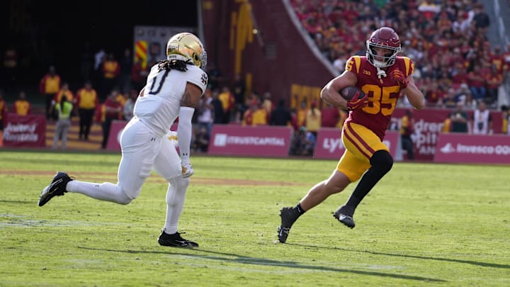 Nov 30, 2024; Los Angeles, California, USA; Southern California Trojans tight end Walker Lyons (85) carries the ball against Notre Dame Fighting Irish safety Xavier Watts (0) in the second half at United Airlines Field at Los Angeles Memorial Coliseum. Mandatory Credit: Kirby Lee-Imagn Images