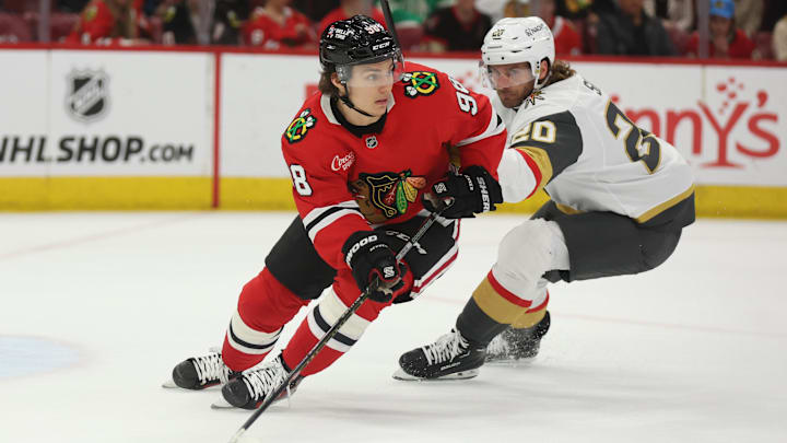 Mar 28, 2025; Chicago, Illinois, USA; Chicago Blackhawks center Connor Bedard (98) and Vegas Golden Knights left wing Brandon Saad (20) battle for control of the puck during the second period at United Center. Mandatory Credit: Talia Sprague-Imagn Images