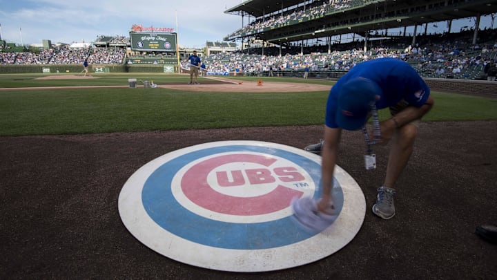 Jun 19, 2017; Chicago, IL, USA; A member of the grounds crew wipes off the Chicago Cubs' on deck logo prior to a game against the San Diego Padres at Wrigley Field. Mandatory Credit: Patrick Gorski-Imagn Images