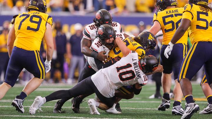 Sep 26, 2026; Morgantown, West Virginia, USA;  Oklahoma State Cowboys linebacker Ethan Wesloski (32) and Oklahoma State Cowboys defensive end James Williams (10) sack West Virginia Mountaineers quarterback Michael Hawkins Jr. (3) during the first quarter at Milan Puskar Stadium.  Mandatory Credit: Ben Queen-Imagn Images