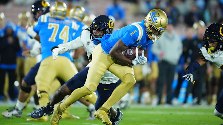 Nov 25, 2023; Pasadena, California, USA; UCLA Bruins wide receiver J. Michael Sturdivant (1) carries the ball against California Golden Bears linebacker Xavier Carlton (44) in the first half at Rose Bowl. Mandatory Credit: Kirby Lee-Imagn Images
