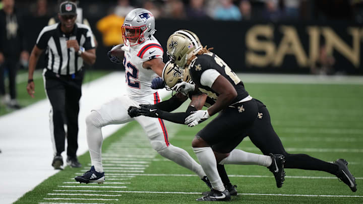 Oct 12, 2025; New Orleans, Louisiana, USA; New England Patriots running back Treveyon Henderson (32) runs for a gain past New Orleans Saints safety Jonas Sanker (33) and cornerback Quincy Riley (29) during the first quarter at Caesars Superdome. Mandatory Credit: Matthew Hinton-Imagn Images