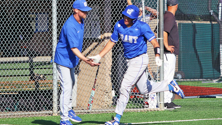 Grant senior Kaeden Cruse shakes hands with Generals coach Matt Kabza as he rounds the bases following his second home run during the 8-2 state semifinal win at Jesuit.