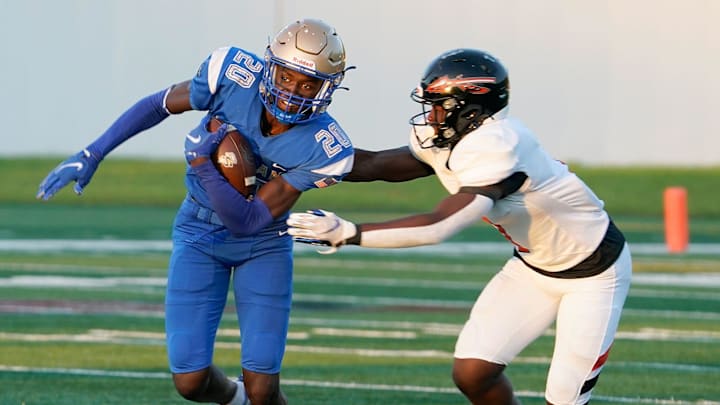 Mainland's Zavier Mincey (20) returns an interception during a game with Seminole at Daytona Stadium