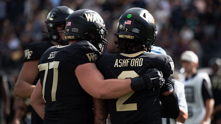 Lineman George Sell puts arm around quarterback Robby Ashford