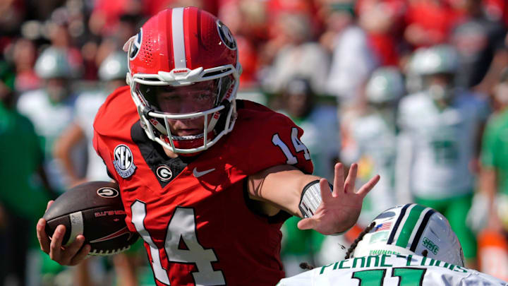 Georgia quarterback Gunner Stockton (14) runs the ball past Marshall defensive back Josh Pierre-Louis (11) during the first half of a NCAA college football game against Marshall in Athens, Ga., on Saturday, August. 30, 2025.