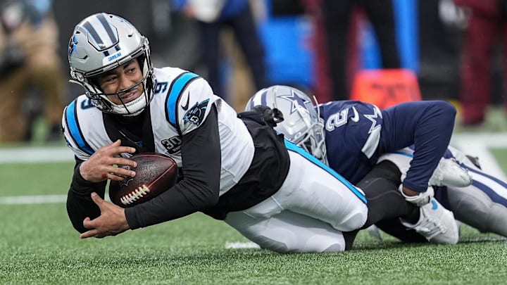 Dec 15, 2024; Charlotte, North Carolina, USA; Carolina Panthers quarterback Bryce Young (9) is sacked by Dallas Cowboys cornerback Jourdan Lewis (2) during the second half at Bank of America Stadium. Mandatory Credit: Jim Dedmon-Imagn Images