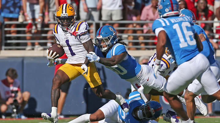 Sep 27, 2025; Oxford, Mississippi, USA;LSU Tigers wide receiver Aaron Anderson (1) runs after a catch as Mississippi Rebels linebacker Jaden Yates (30) makes the tackle during the second quarter at Vaught-Hemingway Stadium. Mandatory Credit: Petre Thomas-Imagn Images