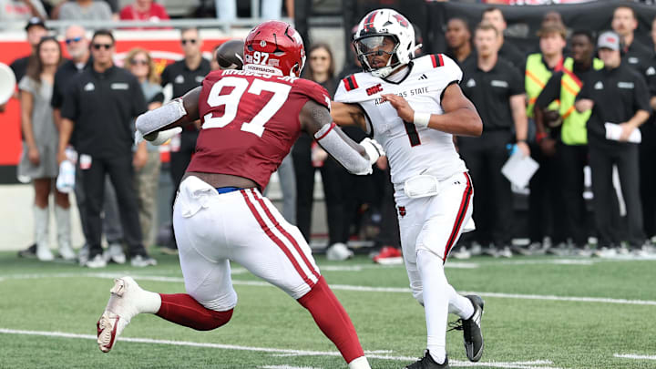Sep 6, 2025; Little Rock, Arkansas, USA; Arkansas State Red Wolves quarterback Jaylen Raynor (1) passes around the defense in the second quarter against the Arkansas Razorbacks at War Memorial Stadium. Mandatory Credit: Nelson Chenault-Imagn Images