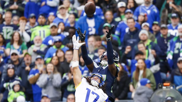 Nov 3, 2024; Seattle, Washington, USA; Seattle Seahawks cornerback Riq Woolen (27) intercepts a pass intended for Los Angeles Rams wide receiver Puka Nacua (17) during the second quarter at Lumen Field. Nacua was ejected following the play. Mandatory Credit: Joe Nicholson-Imagn Images