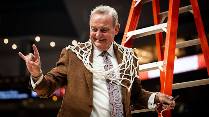 Texas Longhorns head coach Vic Schaefer poses for a photo with the net to celebrate the Longhorns' SEC victory following their win over the Florida Gators, March 2, 2025.