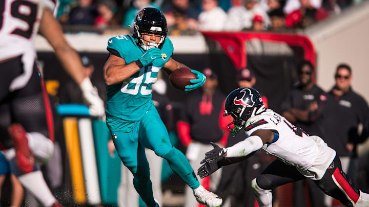 Dec 1, 2024; Jacksonville, Florida, USA; Jacksonville Jaguars tight end Brenton Strange (85) runs after the catch against Houston Texans cornerback Kamari Lassiter (4) in the third quarter  at EverBank Stadium. Mandatory Credit: Jeremy Reper-Imagn Images