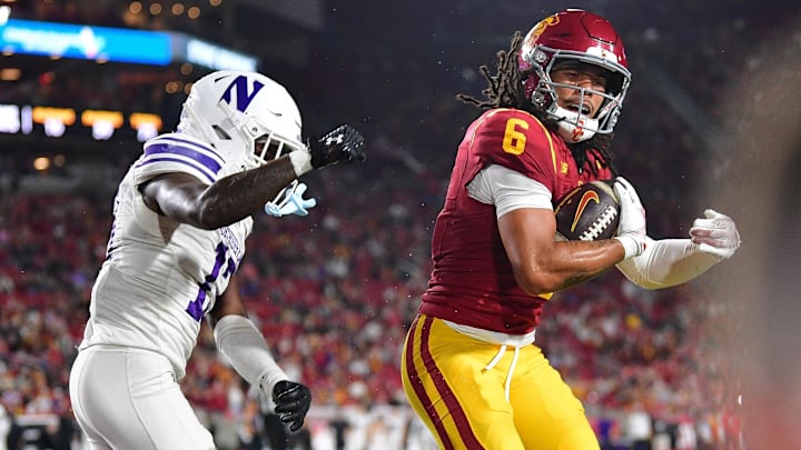 Nov 7, 2025; Los Angeles, California, USA; Southern California Trojans wide receiver Makai Lemon (6) scores a touchdown against Northwestern Wildcats defensive back Josh Fussell (13) during the first half at the Los Angeles Memorial Coliseum. Mandatory Credit: Gary A. Vasquez-Imagn Images