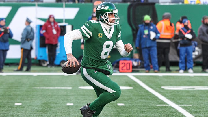 Dec 22, 2024; East Rutherford, New Jersey, USA; New York Jets quarterback Aaron Rodgers (8) scrambles against the Los Angeles Rams during the second half at MetLife Stadium. Mandatory Credit: Vincent Carchietta-Imagn Images