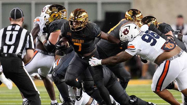 Aug 29, 2025; Waco, Texas, USA; Baylor Bears running back Bryson Washington (7) runs the ball as Auburn Tigers defensive lineman Malik Autry (96) defends during the first half at McLane Stadium. Mandatory Credit: Chris Jones-Imagn Images