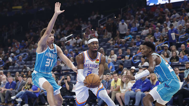 Oct 9, 2025; Oklahoma City, Oklahoma, USA; Oklahoma City Thunder guard Shai Gilgeous-Alexander (2) drives to the basket between Charlotte Hornets forward Tidjane Salaün (31) and forward Brandon Miller (24) during the second quarter of a game between the Charlotte Hornets and the Oklahoma City Thunder at Paycom Center. Mandatory Credit: Alonzo Adams-Imagn Images