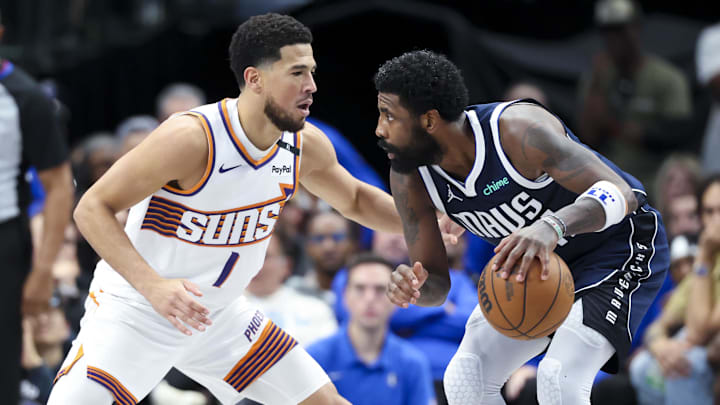Nov 8, 2024; Dallas, Texas, USA;  Dallas Mavericks guard Kyrie Irving (11) controls the ball as Phoenix Suns guard Devin Booker (1) defends during the third quarter at American Airlines Center. Mandatory Credit: Kevin Jairaj-Imagn Images