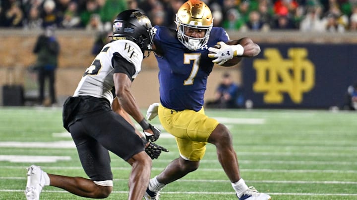 Nov 18, 2023; South Bend, Indiana, USA; Notre Dame Fighting Irish running back Audric Estime (7) runs the ball as Wake Forest Demon Deacons cornerback Jamare Glasker (25) defends in the fourth quarter at Notre Dame Stadium. Mandatory Credit: Matt Cashore-USA TODAY Sports