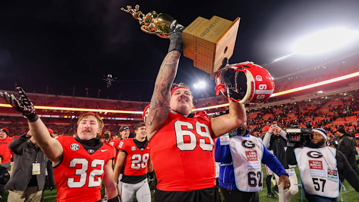 Nov 29, 2024; Athens, Georgia, USA; Georgia Bulldogs offensive lineman Tate Ratledge (69) holds the Governor’s Cup with running back Cash Jones (32) after a victory over the Georgia Tech Yellow Jackets in eight overtimes at Sanford Stadium. Mandatory Credit: Brett Davis-Imagn Images Nov 29, 2024; Athens, Georgia, USA; Georgia Bulldogs offensive lineman Tate Ratledge (69) holds the Governor’s Cup with running back Cash Jones (32) after a victory over the Georgia Tech Yellow Jackets in eight overtimes at Sanford Stadium. Mandatory Credit: Brett Davis-Imagn Images