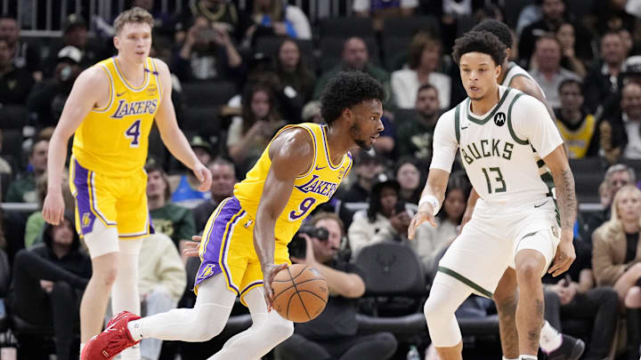 Oct 10, 2024; Milwaukee, Wisconsin, USA; Los Angeles Lakers guard Bronny James (9) drives against Milwaukee Bucks guard Ryan Rollins (13) in the second half at Fiserv Forum. Mandatory Credit: Michael McLoone-Imagn Images