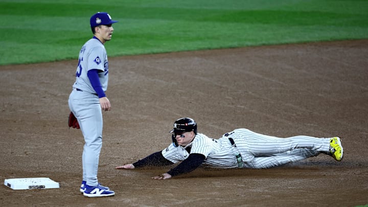 Oct 30, 2024; New York, New York, USA; New York Yankees outfielder Alex Verdugo (24) advances to second on a wild pitch in front of Los Angeles Dodgers outfielder Tommy Edman (25) during the second inning in game five of the 2024 MLB World Series at Yankee Stadium.