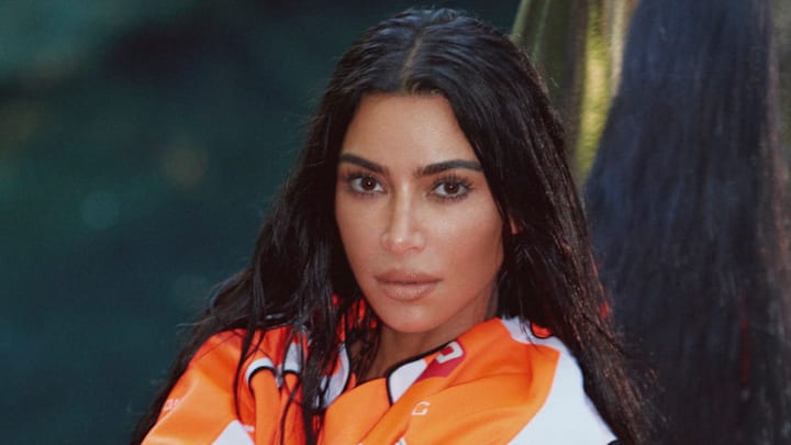 Kim Kardashian was photographed by Greg Swales in the Dominican Republic. Swimsuit by SKIMS. Top by Balenciaga. Gloves by Fox. 