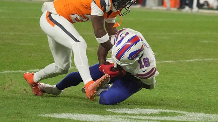 Denver Broncos cornerback Ja'quan McMillian reaches in on Buffalo Bills wide receiver Brandin Cooks who has the ball and whose knee is on the ground during overtime at Empower FIeld at Mile High in Denver, Colorado on Jan. 17, 2026.