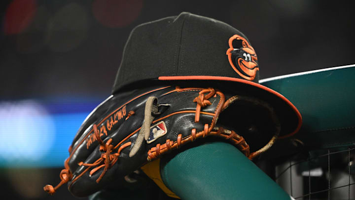May 8, 2024; Washington, District of Columbia, USA; A Baltimore Orioles hat and glove rest on the dugout rail during a game against the Washington Nationals at Nationals Park. Mandatory Credit: Rafael Suanes-Imagn Images