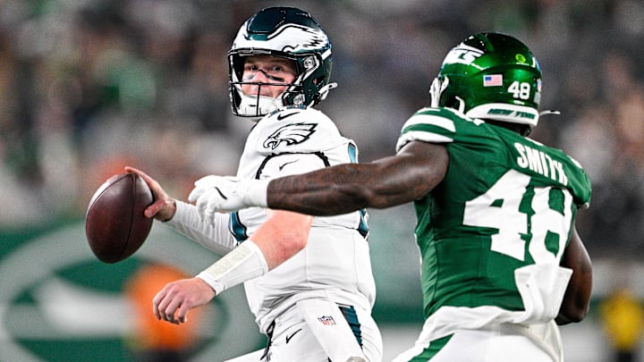 Philadelphia Eagles quarterback Kyle McCord (19) looks to pass the ball, chased by New York Jets linebacker Boog Smith (48) during the third quarter at MetLife Stadium.