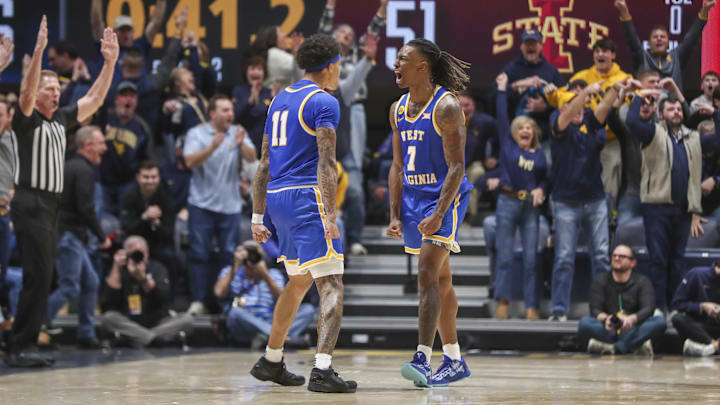 Jan 18, 2025; Morgantown, West Virginia, USA; West Virginia Mountaineers guard Javon Small (7) celebrates with West Virginia Mountaineers guard Jonathan Powell (11) after making a three-point basket late in the second half against the Iowa State Cyclones at WVU Coliseum. Mandatory Credit: Ben Queen-Imagn Images
