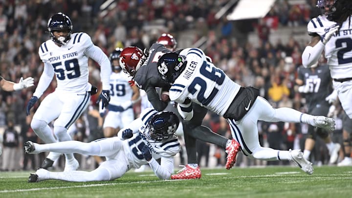 Nov 9, 2024; Pullman, Washington, USA; Washington State Cougars wide receiver Kyle Williams (2) is brought down by Utah State Aggies safety Torren Union (15) and Utah State Aggies linebacker John Miller (26) in the first half at Gesa Field at Martin Stadium. Mandatory Credit: James Snook-Imagn Images
