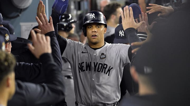 Oct 26, 2024; Los Angeles, California, USA; New York Yankees outfielder Juan Soto (22) celebrates in the dugout after scoring on an RBI single by designated hitter Giancarlo Stanton (not pictured) in the ninth inning against the Los Angeles Dodgers during game two of the 2024 MLB World Series at Dodger Stadium. Mandatory Credit: Jayne Kamin-Oncea-Imagn Images