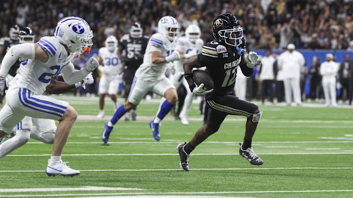 Dec 28, 2024; San Antonio, TX, USA; Colorado Buffaloes wide receiver Travis Hunter (12) runs with the ball and scores a touchdown during the third quarter against the Brigham Young Cougars.