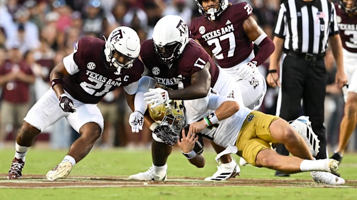 Aug 31, 2024; College Station, Texas, USA; Texas A&M Aggies linebacker Taurean York (21) and defensive lineman Albert Regis (17) tackle Notre Dame Fighting Irish quarterback Riley Leonard (13) during the second quarter at Kyle Field. Mandatory Credit: Maria Lysaker-Imagn Images Aug 31, 2024; College Station, Texas, USA; Texas A&M Aggies linebacker Taurean York (21) and defensive lineman Albert Regis (17) tackle Notre Dame Fighting Irish quarterback Riley Leonard (13) during the second quarter at Kyle Field. Mandatory Credit: Maria Lysaker-Imagn Images