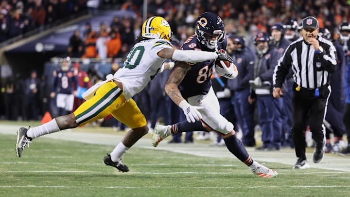 Colston Loveland makes a catch and turns upfield against Javon Bullard of the Packers.