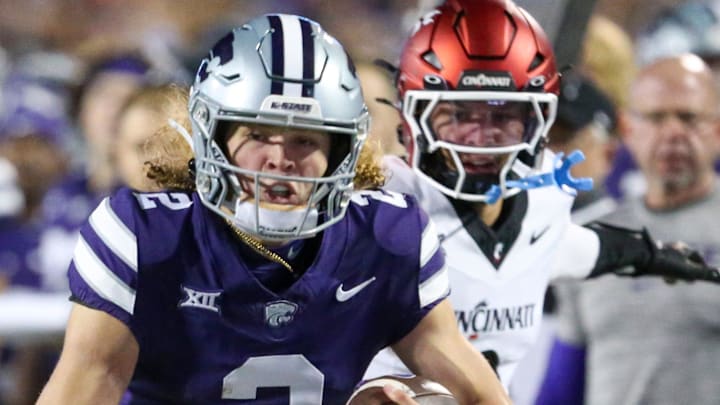 Nov 23, 2024; Manhattan, Kansas, USA; Kansas State Wildcats quarterback Avery Johnson (2) is chased by Cincinnati Bearcats defensive back Josh Minkins (0) during the first quarter at Bill Snyder Family Football Stadium. Mandatory Credit: Scott Sewell-Imagn Images