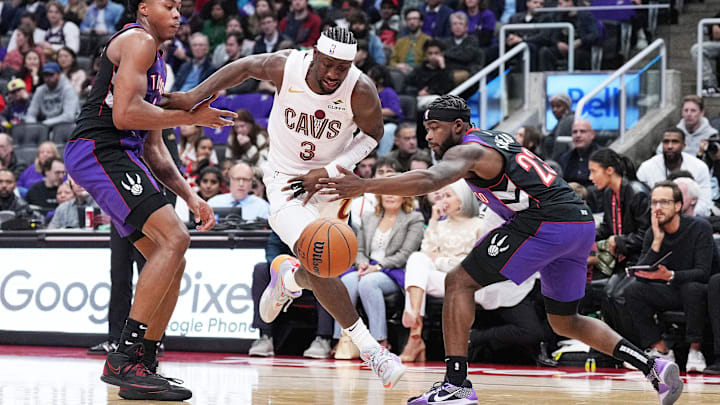Oct 23, 2024; Toronto, Ontario, CAN; Cleveland Cavaliers guard Caris LeVert (3) drives to the basket between Toronto Raptors forward Scottie Barnes (4) and guard Jamal Shead (23) during the third quarter at Scotiabank Arena. Mandatory Credit: Nick Turchiaro-Imagn Images