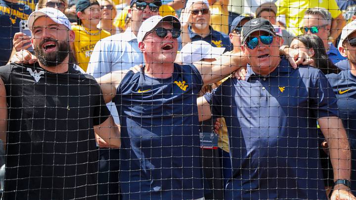 Jun 5, 2026; Morgantown, WV, USA; Pat McAfee and West Virginia head football coach Rich Rodriguez sing “Country Roads” after defeating the Cal Poly Mustangs at Kendrick Family Ballpark. Mandatory Credit: Ben Queen-Imagn Images