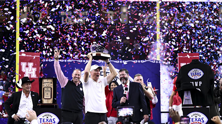 Dec 27, 2025; Houston, TX, USA; Houston Cougars head coach Willie Fritz hoists the Texas Bowl trophy after the win over Louisiana State Tigers at NRG Stadium. Mandatory Credit: Maria Lysaker-Imagn Images Dec 27, 2025; Houston, TX, USA; Houston Cougars head coach Willie Fritz hoists the Texas Bowl trophy after the win over Louisiana State Tigers at NRG Stadium. Mandatory Credit: Maria Lysaker-Imagn Images